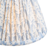 Close-up of the Ashstead LED Leaf Table Lamp's pleated fabric shade, showing a blue and white leaf print with brass lining and piped trim.