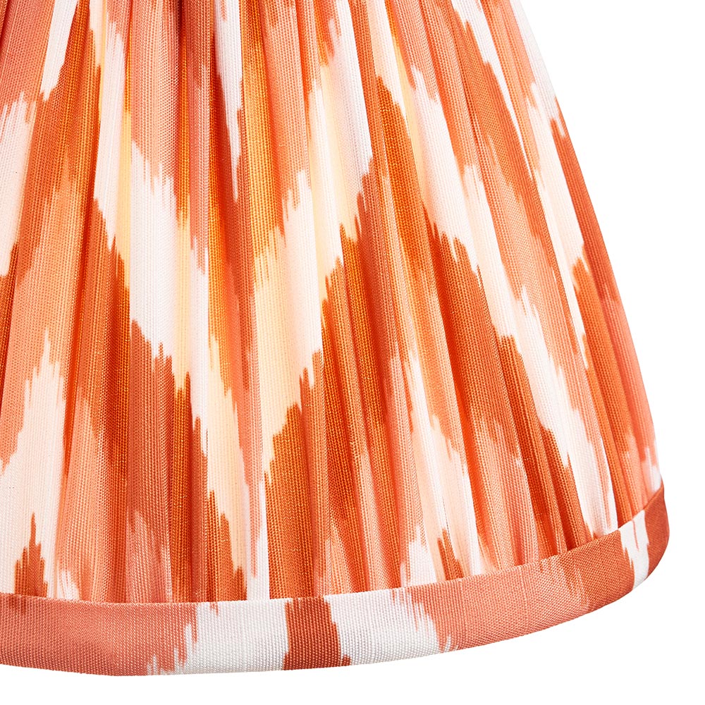 Close-up of the Endon Ashstead table lamp's handmade pleated faux silk shade in apricot orange and white zigzag print with taped edge detail.