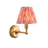 Ashstead LED Ikat Wall Light with brushed brass arm and pleated pink, white and orange patterned fabric shade, shown on a plain white background.