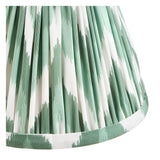 Close-up of the Endon Ashstead LED wall light's pleated zigzag shade in green and white faux silk, showing the fabric detail and trimmed lower edge.