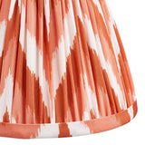 Close-up of the Ashstead LED Zigzag Wall Light shade in orange and white zigzag print faux silk with pleated fabric and trim detail.