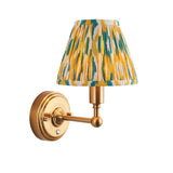 Endon Ashstead LED wall light with brushed brass arm and small tapered pleated Ikat shade in white, yellow and jade, on a plain white background.