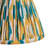 Close-up of Endon Ashstead wall light's pleated Ikat shade in white, yellow and teal digitally printed faux silk.