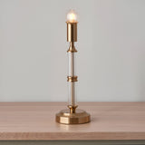 Endon Carlwood LED table lamp with brushed brass base, clear ribbed acrylic column and exposed globe bulb, shown on a wooden surface.