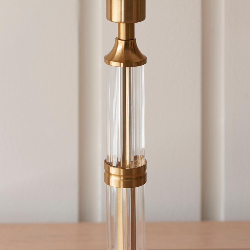 Carlwood LED table lamp close-up showing brass stem with fluted glass column details, set against a neutral background.