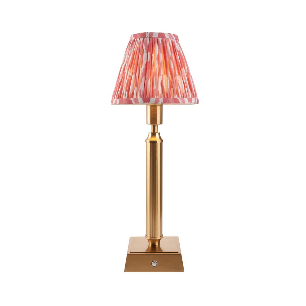 Endon Cranwick LED Ikat cordless table lamp with brushed brass reeded stem, square base and pink and white pleated Ikat shade on a white background.