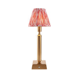 Endon Cranwick LED Ikat cordless table lamp with brushed brass reeded stem, square base and pink and white pleated Ikat shade on a white background.