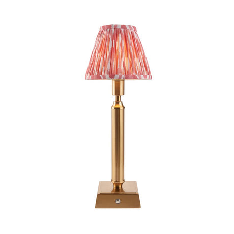 Endon Cranwick LED Ikat cordless table lamp with brushed brass reeded stem, square base and pink and white pleated Ikat shade on a white background.