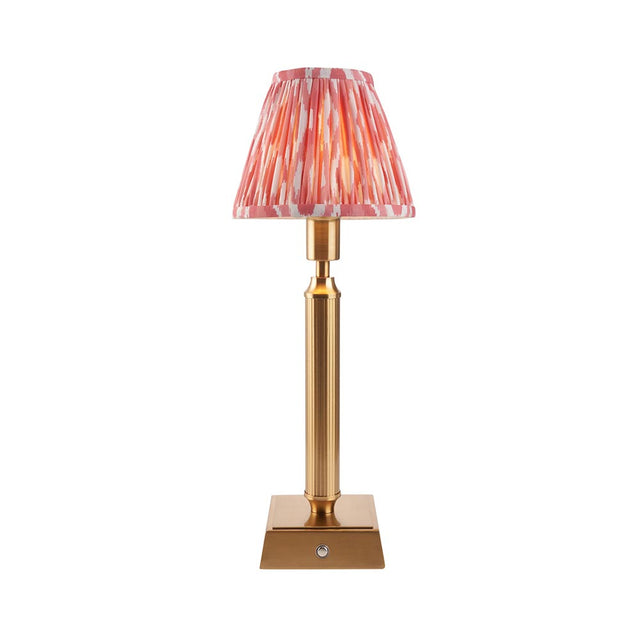 Endon Cranwick LED Ikat cordless table lamp with brushed brass reeded stem, square base and pink and white pleated Ikat shade on a white background.