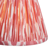 Close-up of the Endon Cranwick LED Ikat table lamp's pleated faux silk shade in coral pink and white digitally printed ikat pattern.