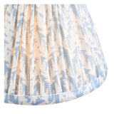 Close-up of the Endon Cranwick LED Leaf table lamp shade in pleated faux linen with a blue and white leaf print and trimmed lower edge.