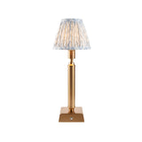 Endon Cranwick LED Leaf table lamp with brushed brass reeded stem, square base and pleated blue and white leaf-print shade on a white background.