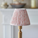 Cranwick LED Leaf Table Lamp with pleated pink and white patterned shade on a reeded brass stem, shown on a fireplace mantel setting.