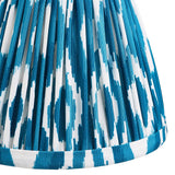 Close-up of the Cranwick LED Ikat Table Lamp's pleated shade, showing blue and white ikat-print faux silk fabric with a brass trim edge.