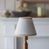 Endon Cranwick rechargeable table lamp with tapered vintage white Ivy fabric shade and reeded brushed brass stem on a mantel setting.
