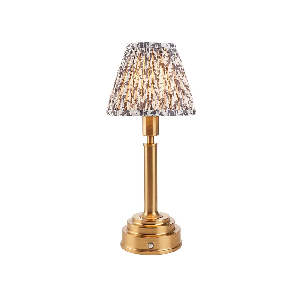 Endon Danebourne LED Leaf table lamp with brushed brass stepped base and tapered pleated shade in white and grey leaf print, on a plain background.