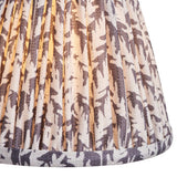 Close-up of the Endon Danebourne LED Leaf table lamp's pleated faux linen shade, showing a grey and white leaf print illuminated from within.