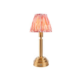 Endon Danebourne LED table lamp with brushed brass stepped base and pink and white Ikat pleated clip-on shade, on a plain white background.