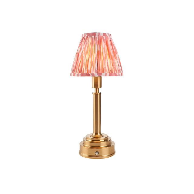 Endon Danebourne LED table lamp with brushed brass stepped base and pink and white Ikat pleated clip-on shade, on a plain white background.