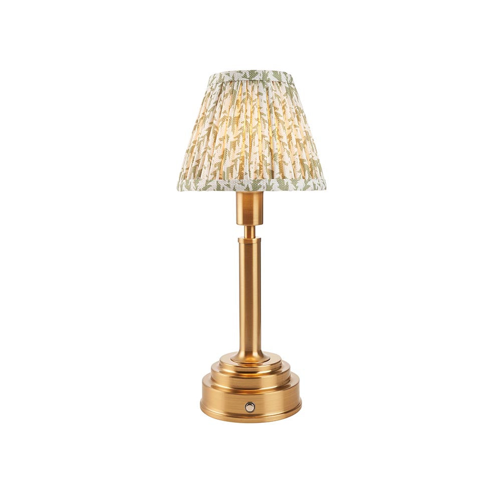 Endon Danebourne LED Leaf table lamp with brushed brass stepped base and tapered pleated shade in green and white leaf print, on a white background.