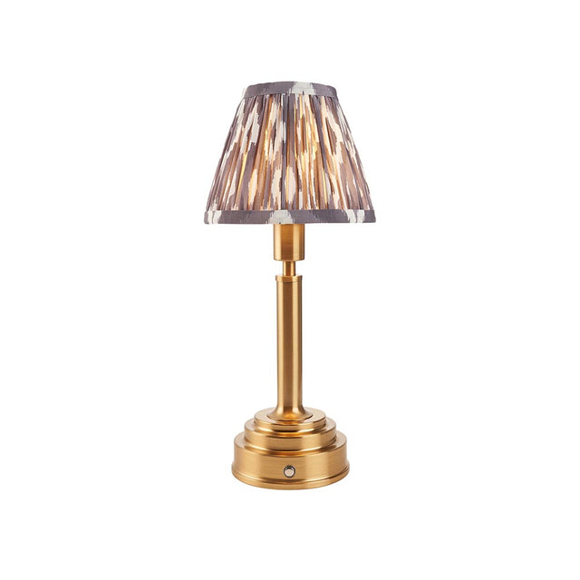 Endon Danebourne LED Ikat table lamp with brushed brass stepped base and grey, white and cream patterned faux silk clip-on shade, on a white background.