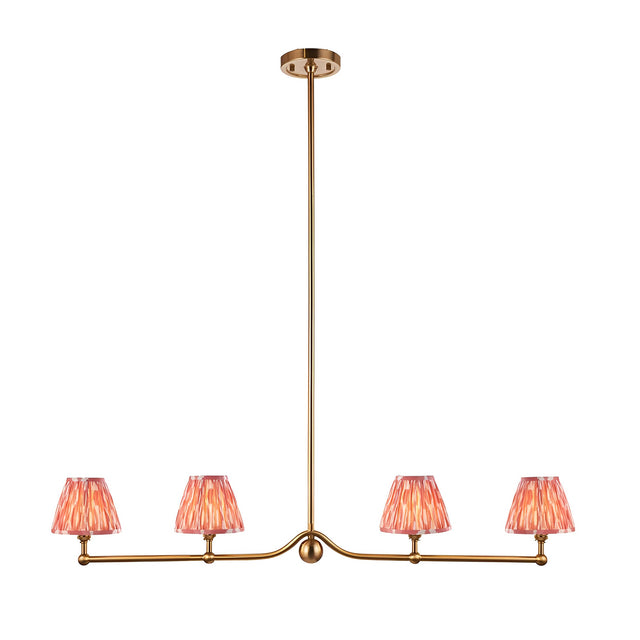 Endon Cliffleigh 4 light linear pendant in brushed aged brass with four coral pink pleated faux silk taper shades, shown on a white background.