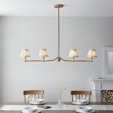 Endon Cliffleigh Leaf 4 light linear pendant in brushed brass with four tapered blue Leaf print shades, shown above a dining table.