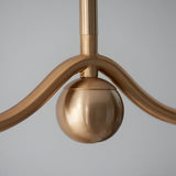 Close-up of the Endon Cliffleigh Leaf linear pendant showing the brushed aged brass sphere detail between curved arms against a plain background.