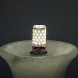 Close-up of the Morfia mushroom alabaster table lamp's E27 LED bulb glowing inside its brass fitting, set into the carved alabaster stem against a dark background.