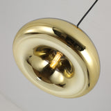 The Gulf Mini Glass Pendant Light - Brass features a modern, glossy doughnut-shaped design with an exposed filament bulb at the center, offering striking compact pendant lighting for any ceiling.