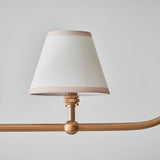 Endon Cliffleigh pendant detail showing a tapered white cotton shade with almond taped edge on a brushed aged brass arm with sphere detail.