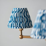 Close-up of the Cliffleigh 5 Light Ripple Pendant in blue, showing a pleated fabric shade with wavy pattern on a brushed brass fitting, light grey background.