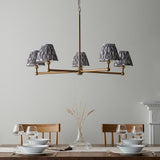 Cliffleigh Ikat 5 Light Pendant in brushed brass with pleated grey Ikat fabric shades, shown above a dining table in a light-toned room.