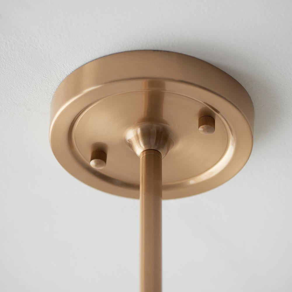 Close-up of the Cliffleigh Ikat pendant's brushed brass ceiling rose with adjustable stem and grey fabric flex against a plain white ceiling.