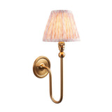 Endon Cliffleigh Leaf Wall Light II in brass with a curved arm and tapered pleated faux linen shade in peach leaf print, on a white background.