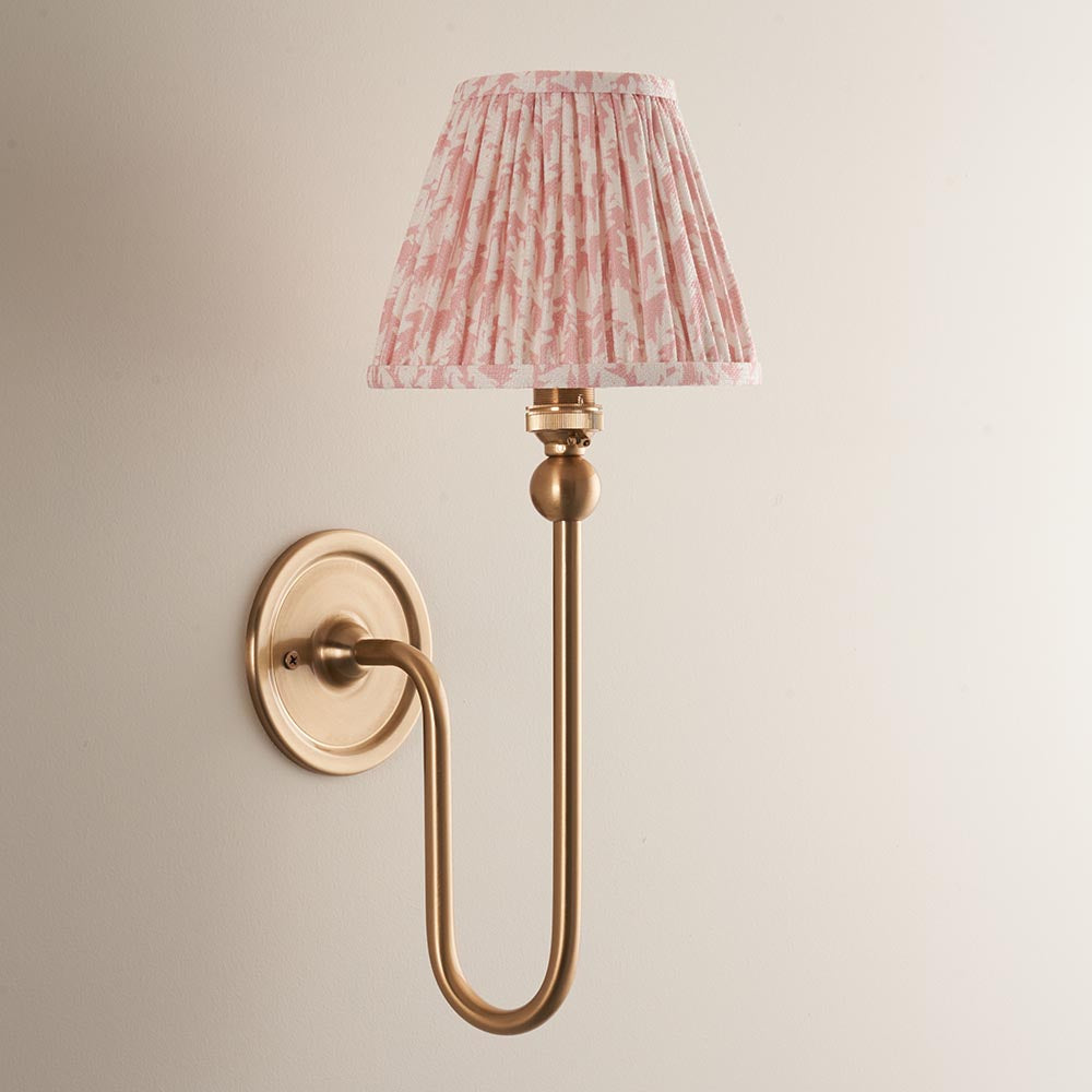 Endon Cliffleigh Leaf wall light in brushed brass with curved arm, round backplate, and pleated pink leaf-print faux linen tapered shade.