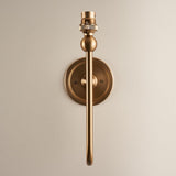 Cliffleigh Ikat Wall Light II in brushed aged brass, showing the long curved arm, ball joint, bulb holder, and round wall backplate on a plain background.