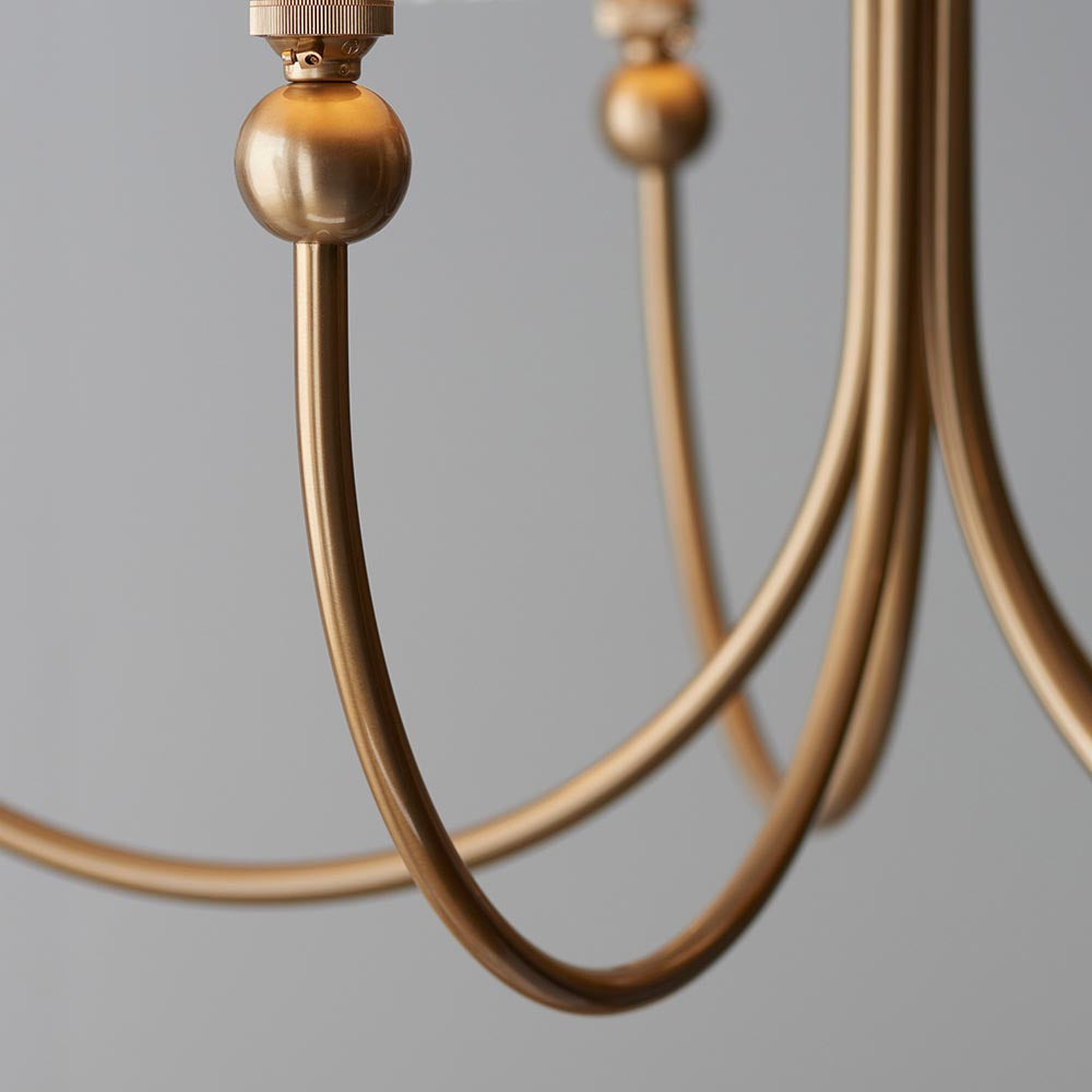 Close-up of the Cliffleigh Leaf 5 Light Curved Arm Pendant, showing brushed brass curved arms and ball joint detail against a plain grey background.