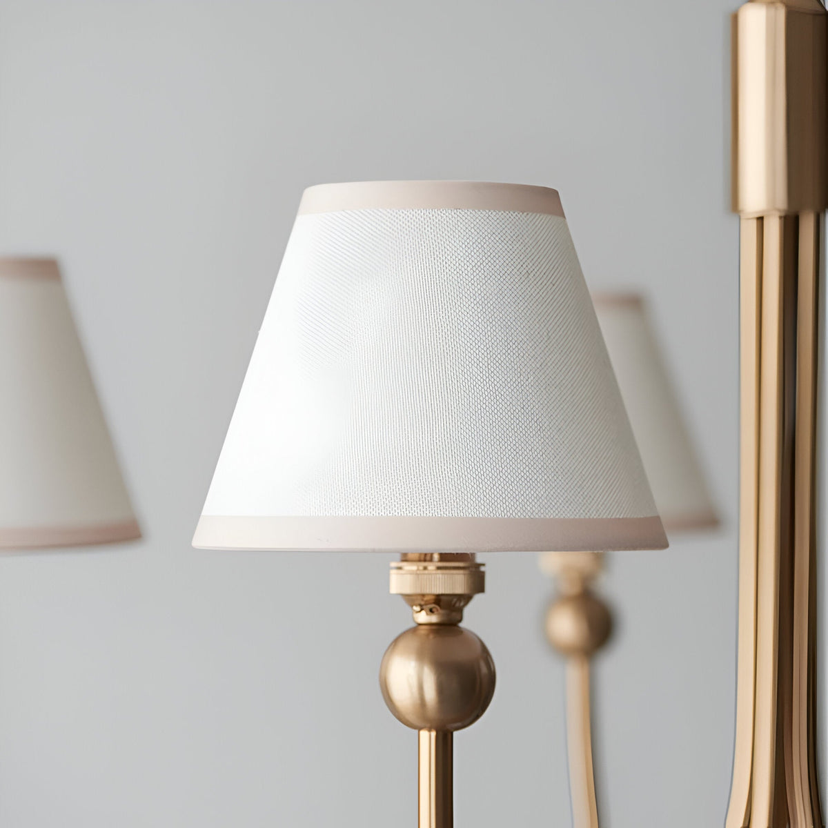 Close-up of the Cliffleigh 5 Light Curved Arm Ivy Pendant in white, showing a tapered fabric shade with pink-toned trim on a brushed brass frame.
