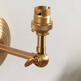 Close-up of the Endon Castley wall light showing the brushed aged brass B22 lampholder, adjustable knuckle arm, and stepped wall back.