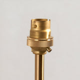 Close-up of the Endon Brackfield Wall Light's brushed aged brass B22 lampholder and knurled shade ring atop a slim arm against a plain white wall.