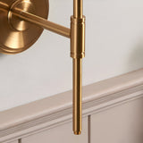 Close-up of the Endon Cliffworth wall light showing the brushed aged brass stepped back plate, T-bar arm, and cylindrical lampholder above panelling.