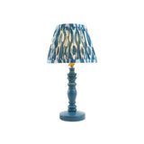 Endon Aldworth Ikat table lamp with turned marlin blue spindle base, brass B22 lampholder and pleated blue ikat print faux silk shade, on white.
