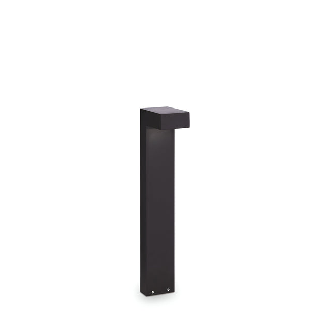 The Luma Outdoor Bollard Light in black, measuring 60cm, boasts a sleek and modern rectangular design with an overhanging top. This durable lighting fixture features a Pyrex glass diffuser and is displayed unlit against a plain white background.