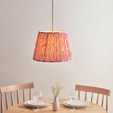 Endon Brackmont Ikat Coral pendant with handmade pleated faux silk shade and green braided cable, hung above a wooden dining table set for two.