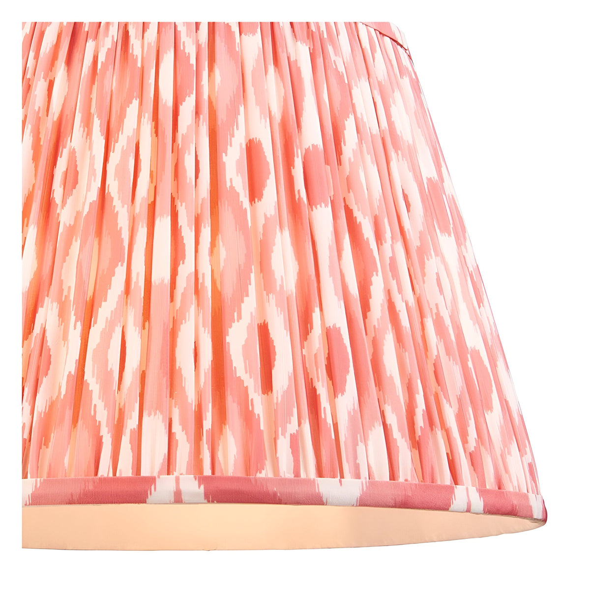 Endon Brackmont Ikat pendant shade in coral pink faux silk with handmade pleated taper and taped edge detailing, shown lit from within.