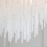 Close-up of the Endon Aldfield 5 Light Pendant showing tiered twisted clear glass rods with rounded tips, illuminated against a soft neutral background.