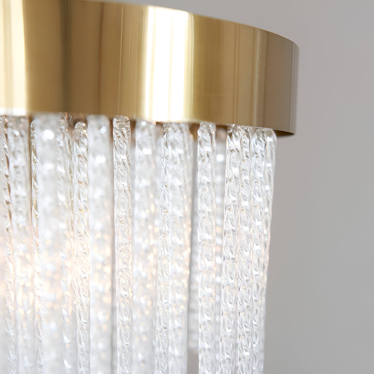 Close-up of Endon Aldfield 5 Light Pendant showing brushed brass frame and textured clear glass rods hanging in a tiered arrangement.