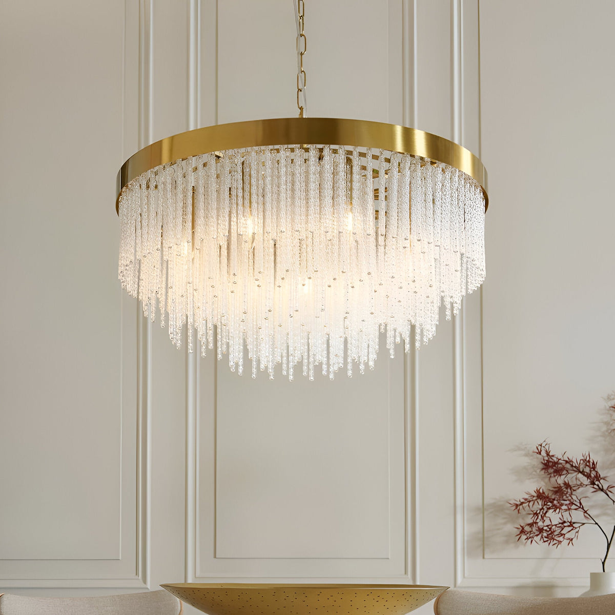Aldfield nine-light pendant with brushed brass frame and tiered clear glass rods, hung above a dining area in a panelled room.
