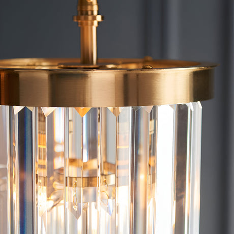 Close-up of the Endon Bevstead pendant showing its brushed aged brass frame and tiered cascade of clear lozenge-shaped glass drops.
